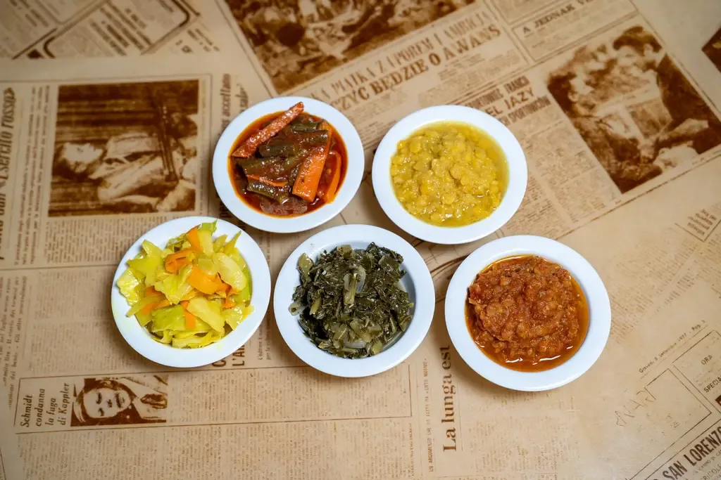 Six small bowls of Ethiopian stews and vegetables in a sampler arrangement. Taste of Ethiopia.