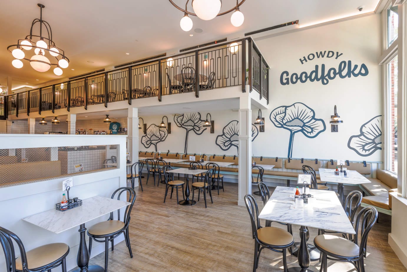 Bright two-level restaurant interior with Howdy Goodfolks sign. Goodfolks.